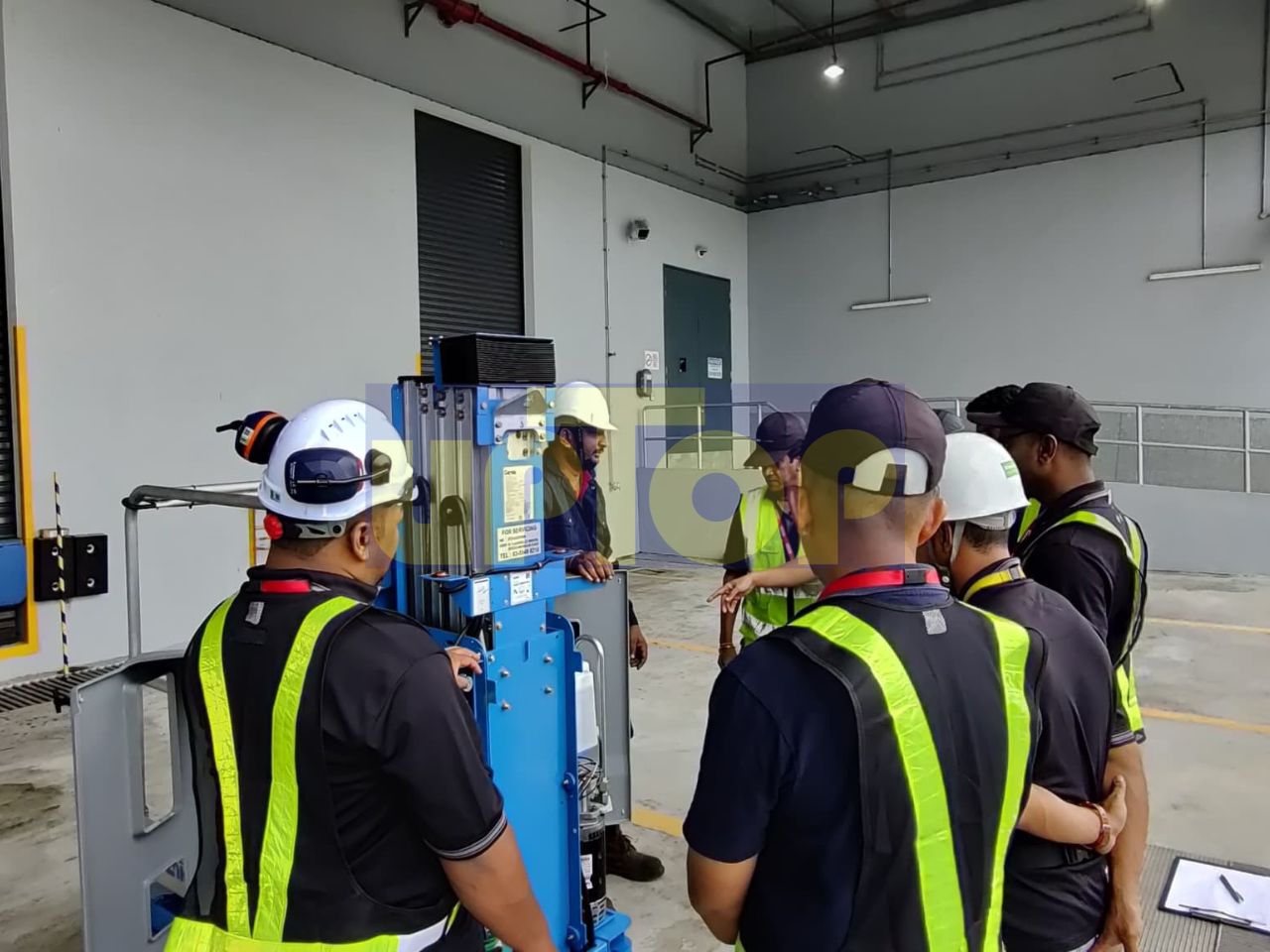 MEWP operator trainees inspecting a vertical mast lift's controls.