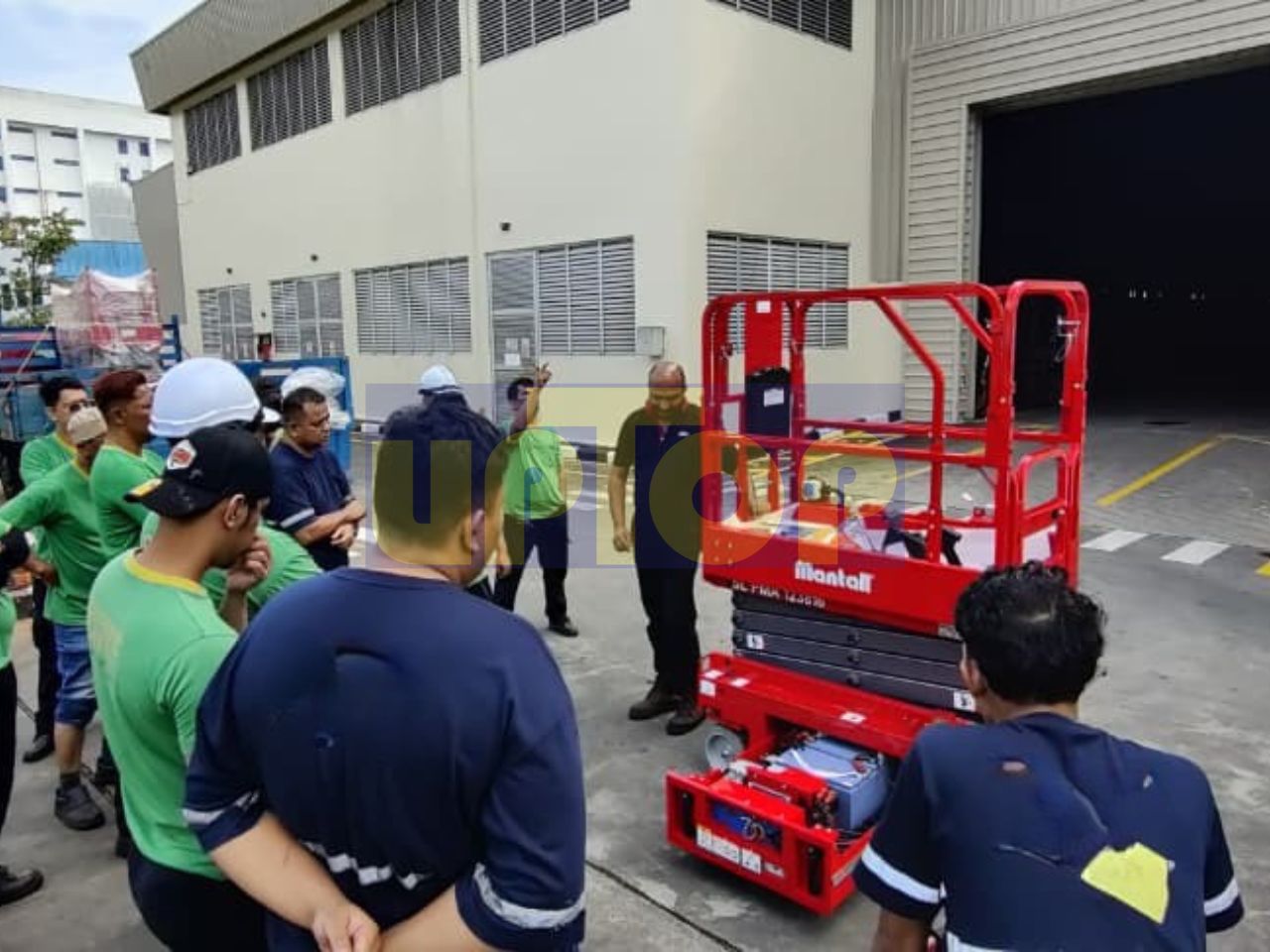 Instructor leads practical MEWP training on a red scissor lift.